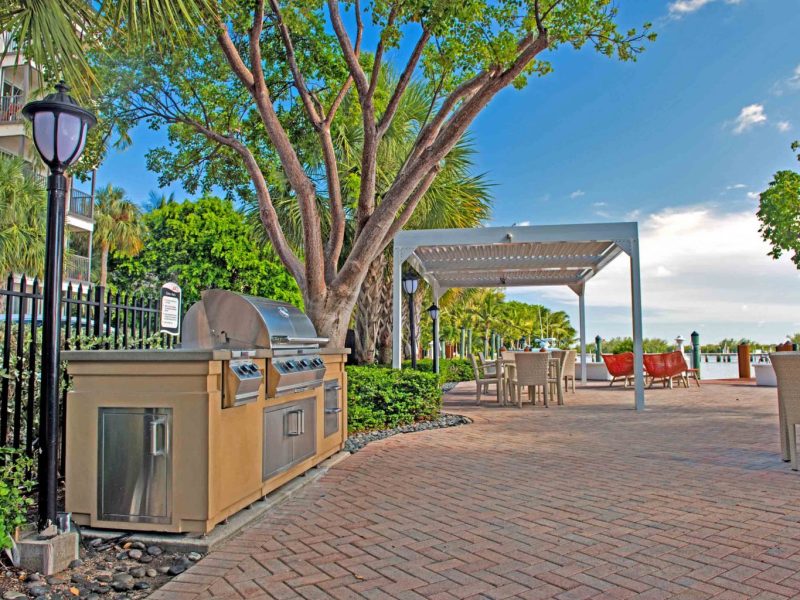 This image shows the outdoor kitchen, featuring the grilling area and lounge area with waterfront on it. This area was ideal during leisure, daytime, and sunset scenery.